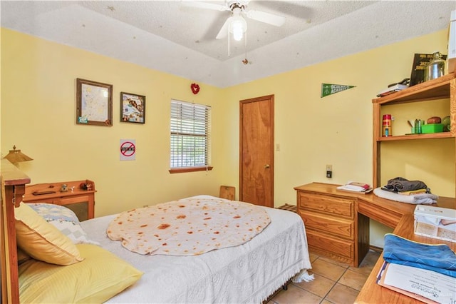 tiled bedroom featuring ceiling fan and a textured ceiling