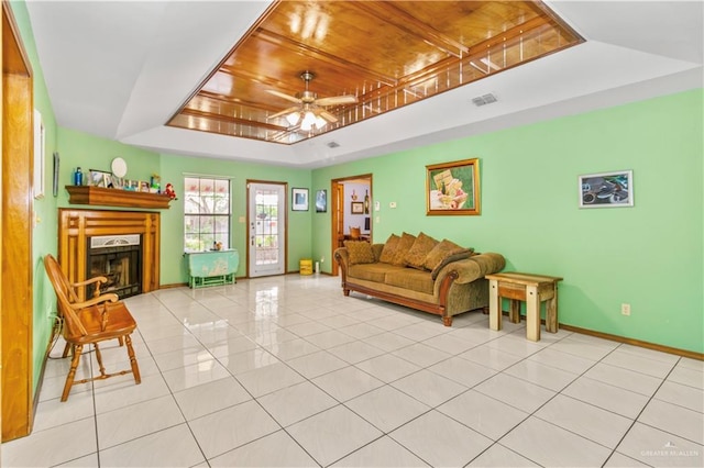 living room with a raised ceiling, ceiling fan, light tile patterned floors, and wood ceiling