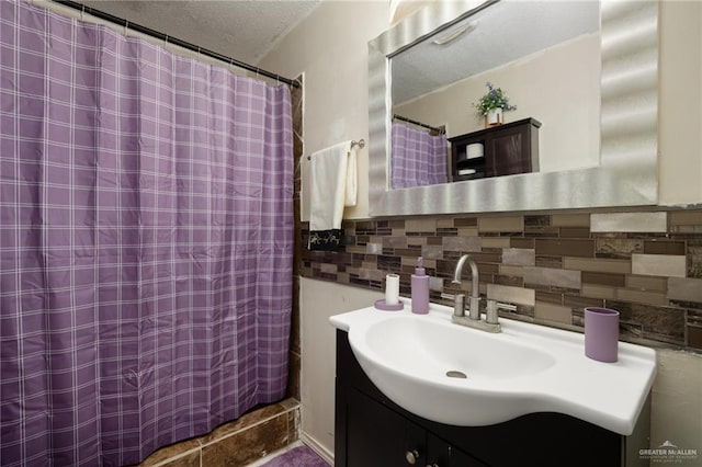 bathroom featuring vanity, decorative backsplash, curtained shower, and a textured ceiling