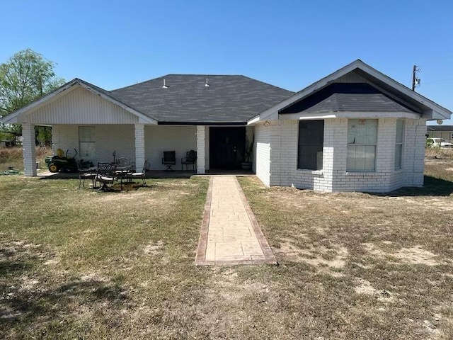 view of front of home with brick siding and a front lawn