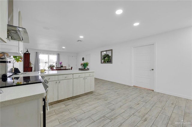 117 W Hawk Ave, Pharr, TX 78577 - kitchen featuring recessed lighting, a peninsula, electric stove, light wood-style floors, and white cabinetry