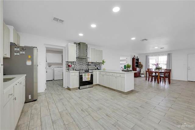 117 W Hawk Ave, Pharr, TX 78577 - kitchen with appliances with stainless steel finishes, wall chimney range hood, a peninsula, independent washer and dryer, and light countertops