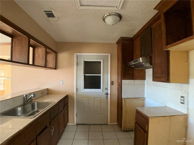 3823 Seles Dr, Weslaco, TX 78599 - kitchen featuring sink, light tile patterned floors, a textured ceiling, and decorative backsplash