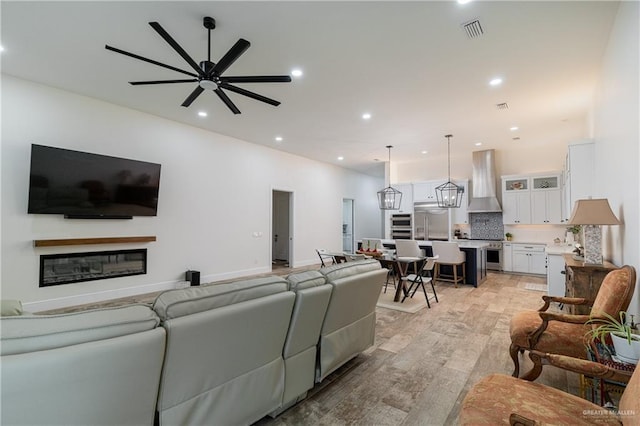 living room with ceiling fan and light hardwood / wood-style floors