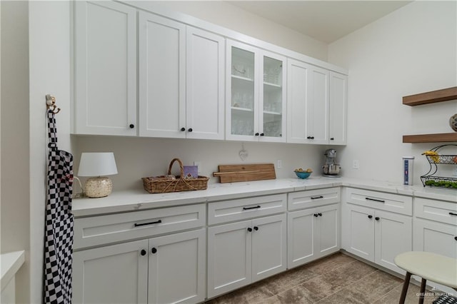 kitchen featuring white cabinetry and light stone countertops