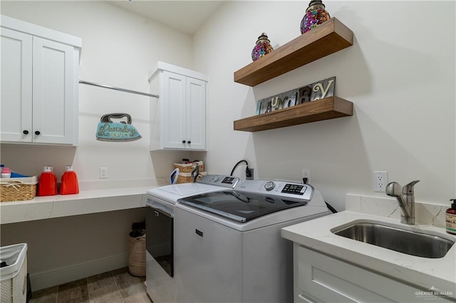 clothes washing area featuring separate washer and dryer, sink, and cabinets