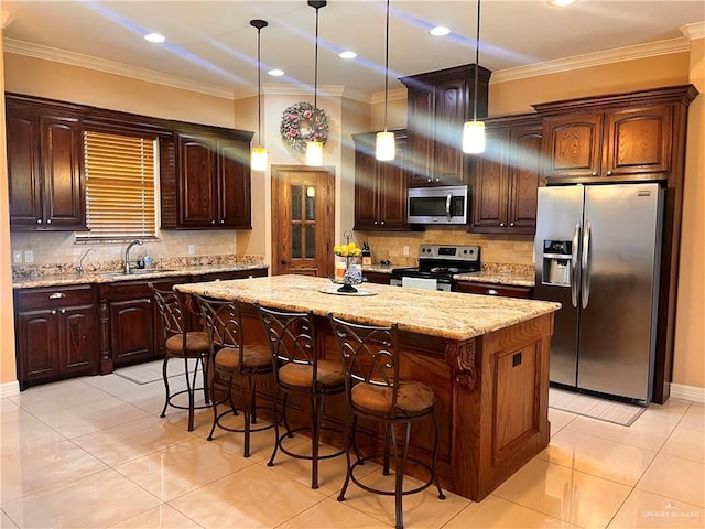 917 Beddoes Rd, La Feria, TX 78559 - kitchen with appliances with stainless steel finishes, a center island, backsplash, crown molding, and a breakfast bar