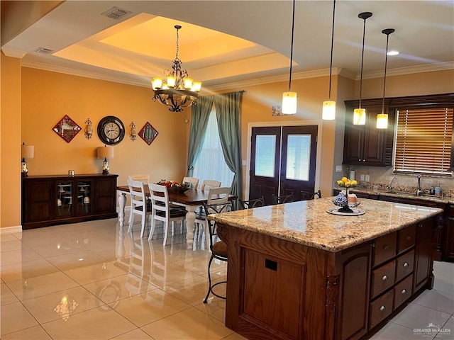 917 Beddoes Rd, La Feria, TX 78559 - kitchen featuring light tile patterned floors, light stone countertops, a kitchen island, arched walkways, and ornamental molding