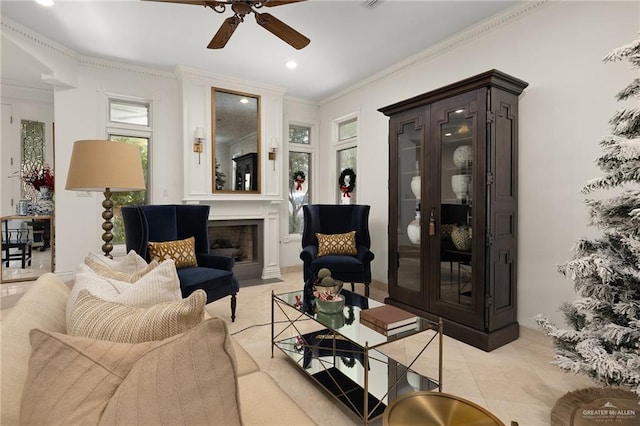 tiled living room with ceiling fan and crown molding