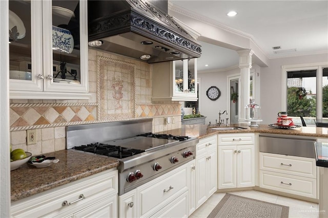 kitchen featuring ornate columns, sink, premium range hood, dark stone counters, and stainless steel gas stovetop