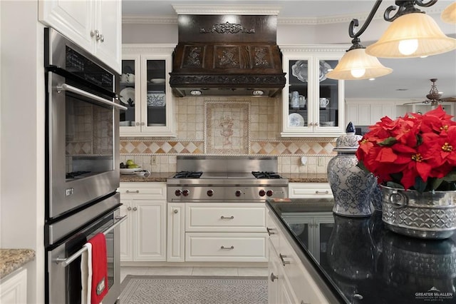 kitchen with white cabinets, custom exhaust hood, light tile patterned flooring, and stainless steel appliances