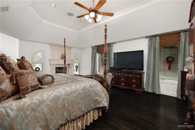 bedroom featuring dark hardwood / wood-style floors, a raised ceiling, ceiling fan, and crown molding