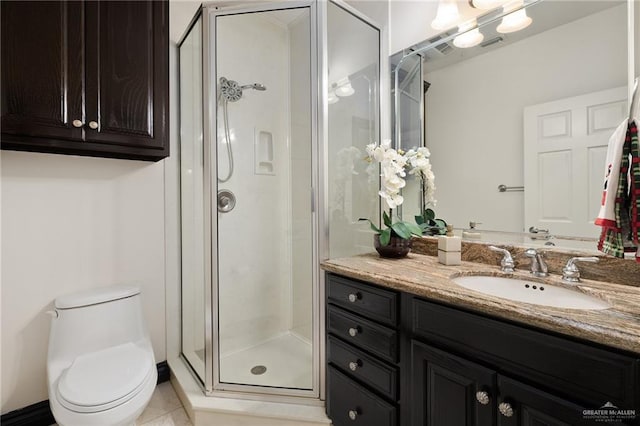 bathroom featuring toilet, vanity, tile patterned floors, and a shower with shower door