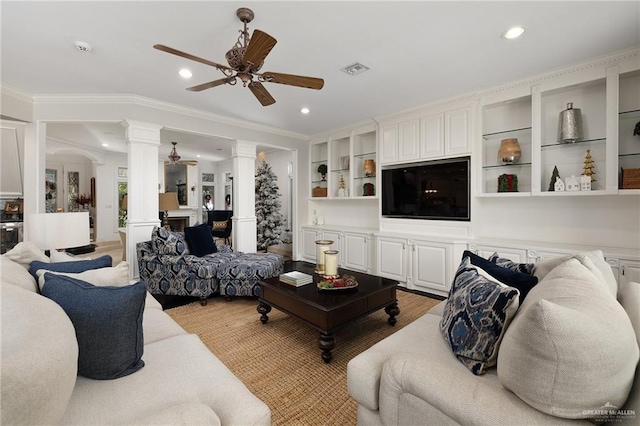 living room with light hardwood / wood-style flooring, ornate columns, ceiling fan, and ornamental molding