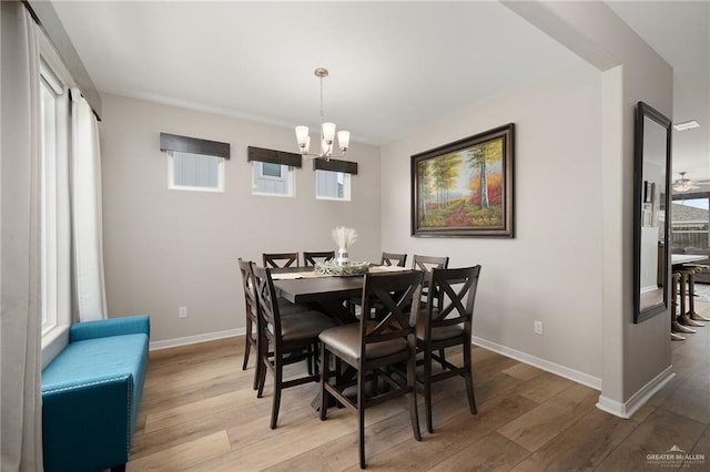 dining area featuring light wood-type flooring and an inviting chandelier