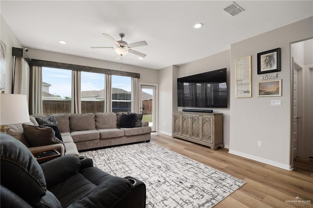 living room with ceiling fan and light hardwood / wood-style flooring