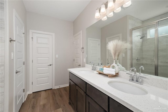 bathroom with hardwood / wood-style floors, vanity, and a shower with shower door