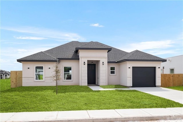 prairie-style home featuring a garage and a front lawn