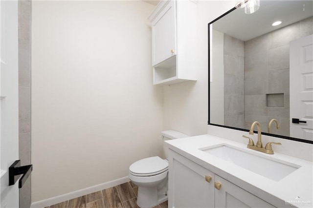 bathroom with vanity, wood-type flooring, and toilet