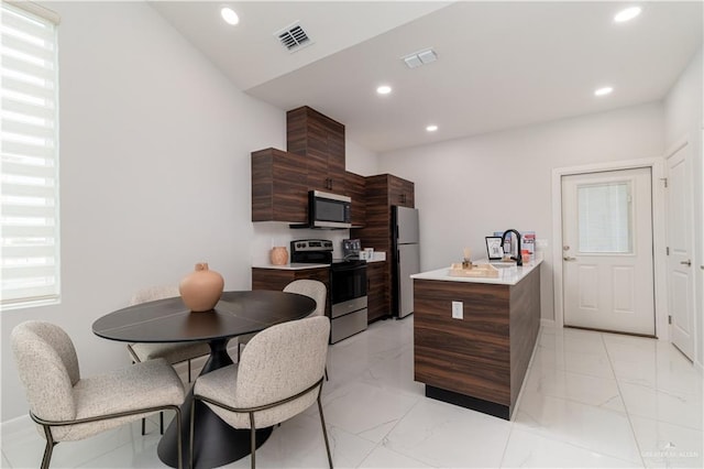 kitchen featuring appliances with stainless steel finishes and a kitchen island with sink