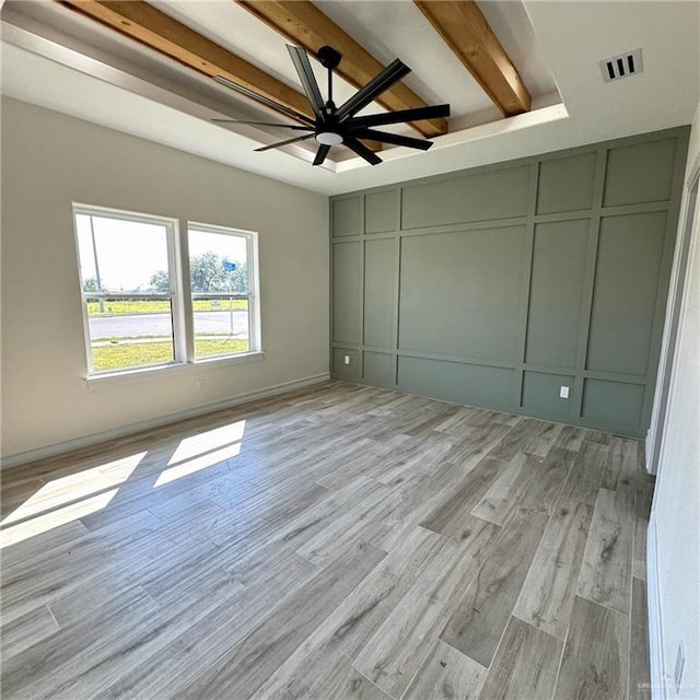 unfurnished bedroom featuring beam ceiling, light hardwood / wood-style flooring, a closet, and ceiling fan