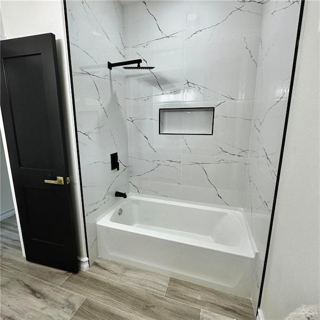 bathroom with hardwood / wood-style floors and tiled shower / bath combo