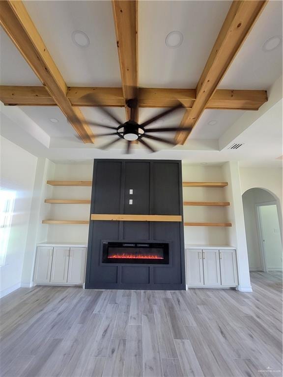 unfurnished living room with ceiling fan, beam ceiling, and light hardwood / wood-style flooring