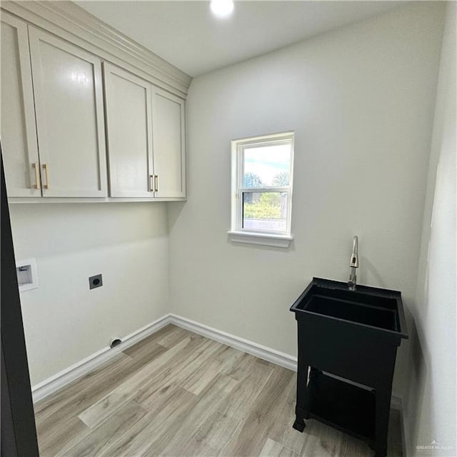 laundry room with cabinets, hookup for a washing machine, light wood-type flooring, and electric dryer hookup