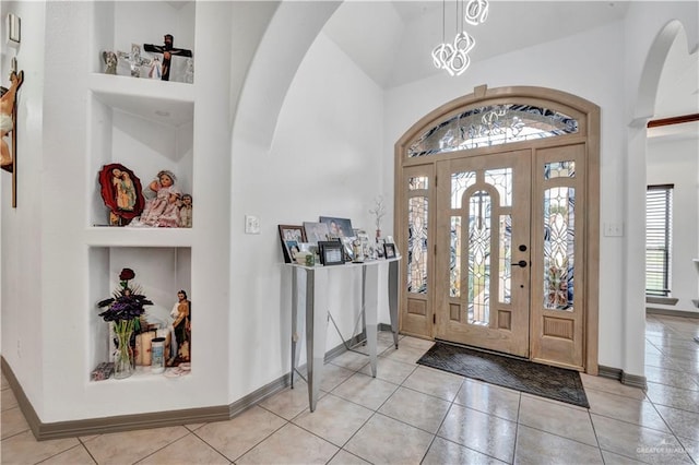 3501 N 39th St, Mcallen, TX 78501 - entryway with high vaulted ceiling, arched walkways, a notable chandelier, light tile patterned floors, and baseboards