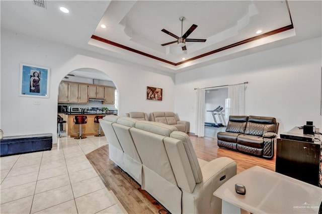 3501 N 39th St, Mcallen, TX 78501 - living room with light wood finished floors, visible vents, a raised ceiling, ceiling fan, and arched walkways