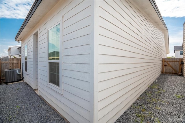 view of property exterior featuring cooling unit and fence