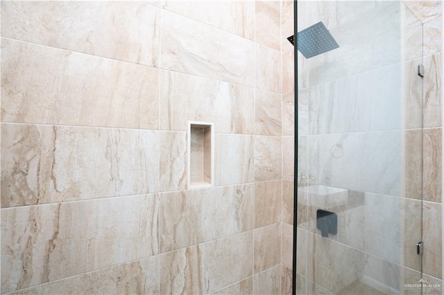 interior details featuring tiled shower