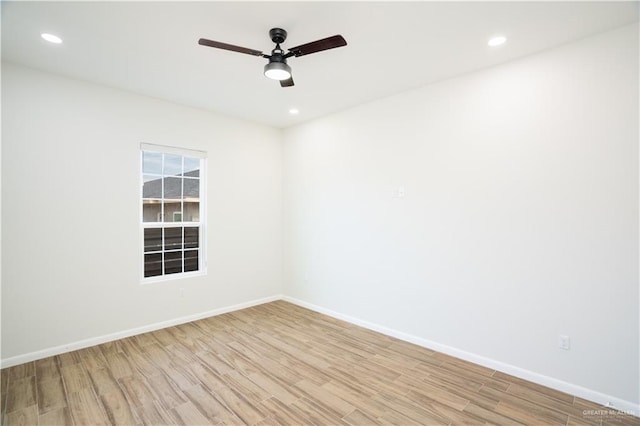 spare room featuring light wood-type flooring, baseboards, and recessed lighting