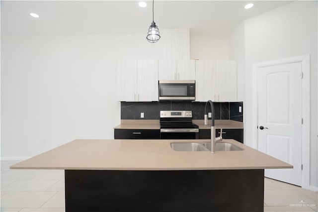 kitchen with stainless steel appliances, a sink, light countertops, and decorative backsplash