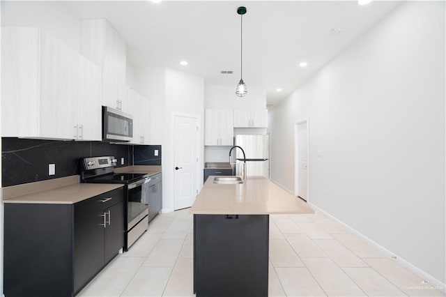 kitchen with stainless steel appliances, light countertops, a sink, and decorative backsplash