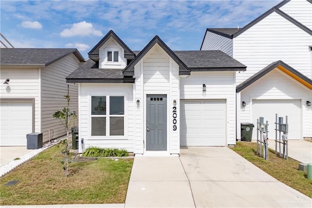 view of front of property with concrete driveway and a shingled roof