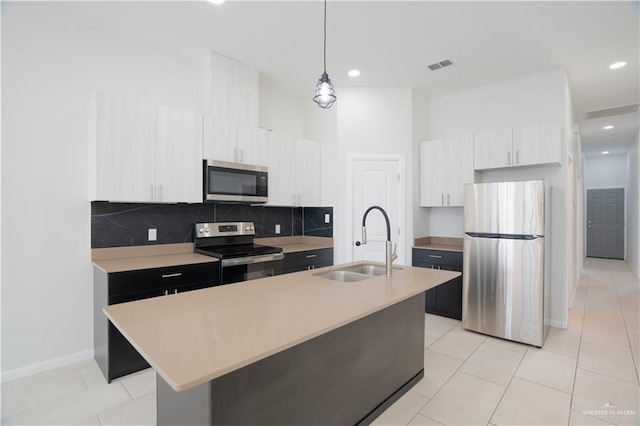 kitchen featuring appliances with stainless steel finishes, light countertops, a sink, and visible vents