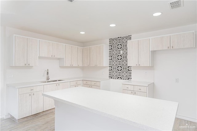 kitchen featuring a center island, sink, and light hardwood / wood-style flooring