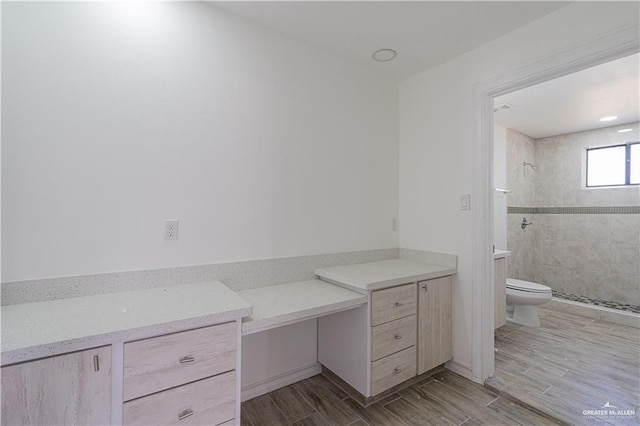 bathroom featuring toilet and tiled shower