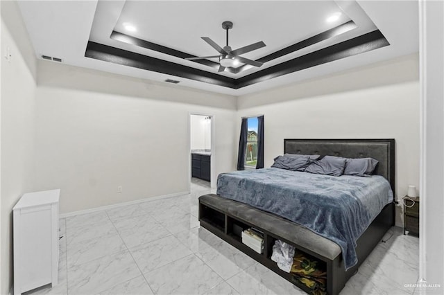 bedroom with a tray ceiling, marble finish floor, visible vents, and baseboards