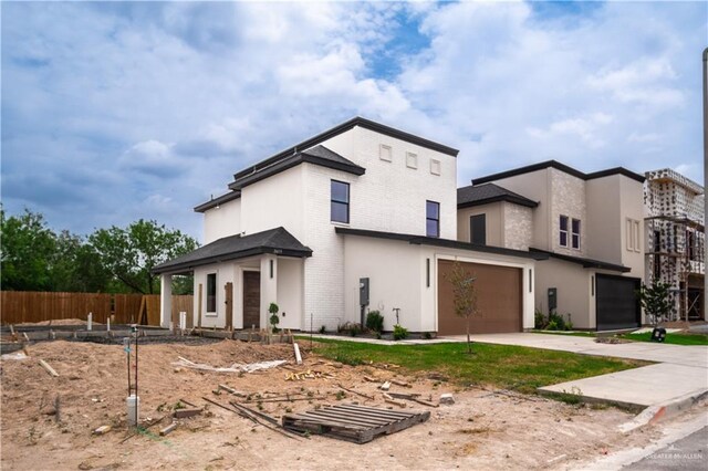 2609 E Solar Dr, Mission, TX 78574 - contemporary home featuring driveway, a garage, brick siding, and stucco siding