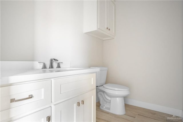 2609 E Solar Dr, Mission, TX 78574 - bathroom featuring vanity, toilet, wood finished floors, and baseboards