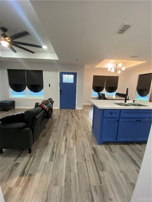814 N Flag St N, Pharr, TX 78577 - kitchen featuring open floor plan, blue cabinetry, ceiling fan, light countertops, and light wood-type flooring