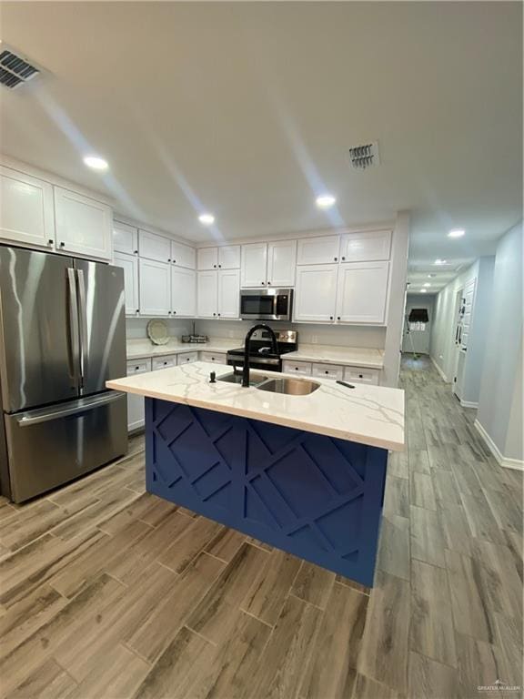 814 N Flag St N, Pharr, TX 78577 - kitchen featuring appliances with stainless steel finishes, white cabinets, light wood finished floors, light stone countertops, and recessed lighting