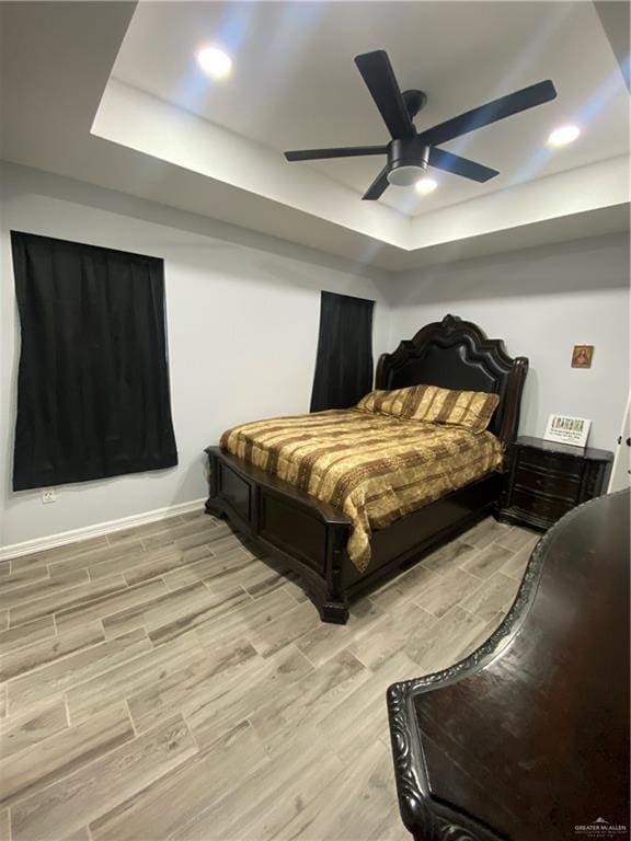 814 N Flag St N, Pharr, TX 78577 - bedroom with a tray ceiling, light wood-type flooring, and a ceiling fan