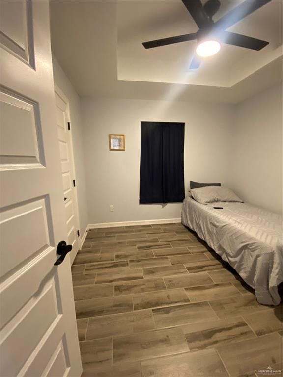 814 N Flag St N, Pharr, TX 78577 - bedroom featuring wood tiled floors, a ceiling fan, and a tray ceiling