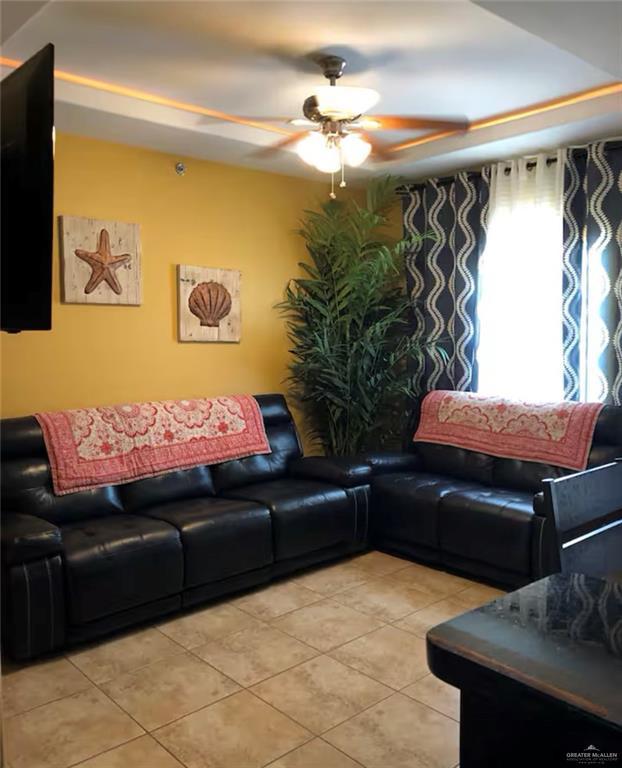 tiled living room with ceiling fan