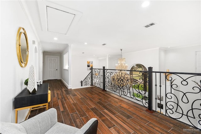 corridor featuring dark hardwood / wood-style flooring, a chandelier, and ornamental molding