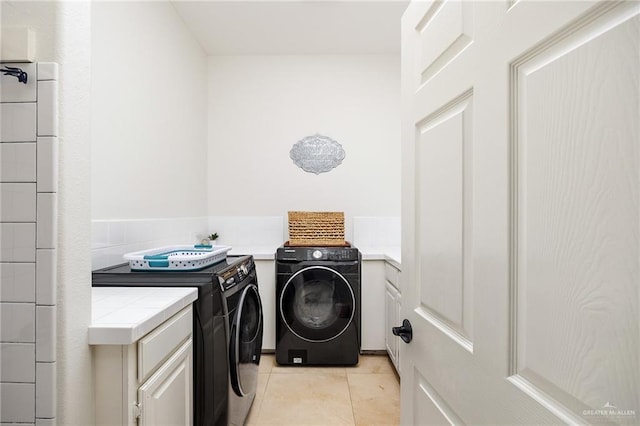 laundry room featuring cabinets, independent washer and dryer, and light tile patterned flooring