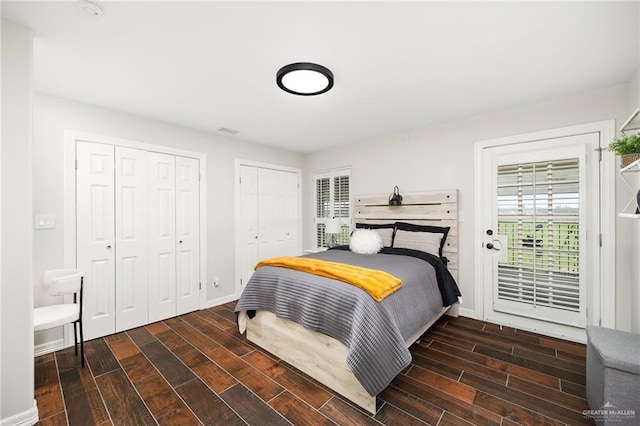 bedroom with multiple closets and dark hardwood / wood-style floors